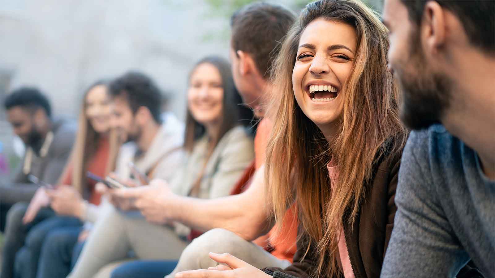 Young women laughing as people sit together